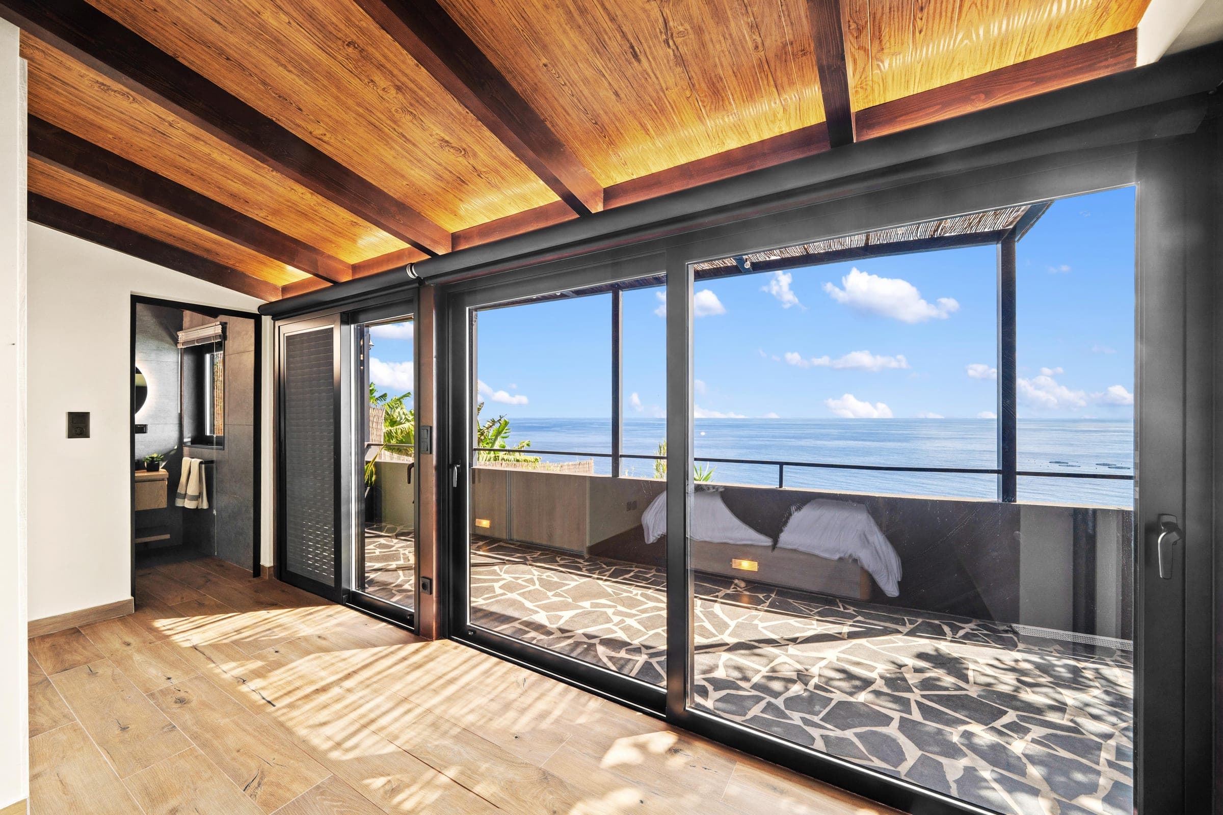 Bedroom terrace doors framing the Atlantic horizon.